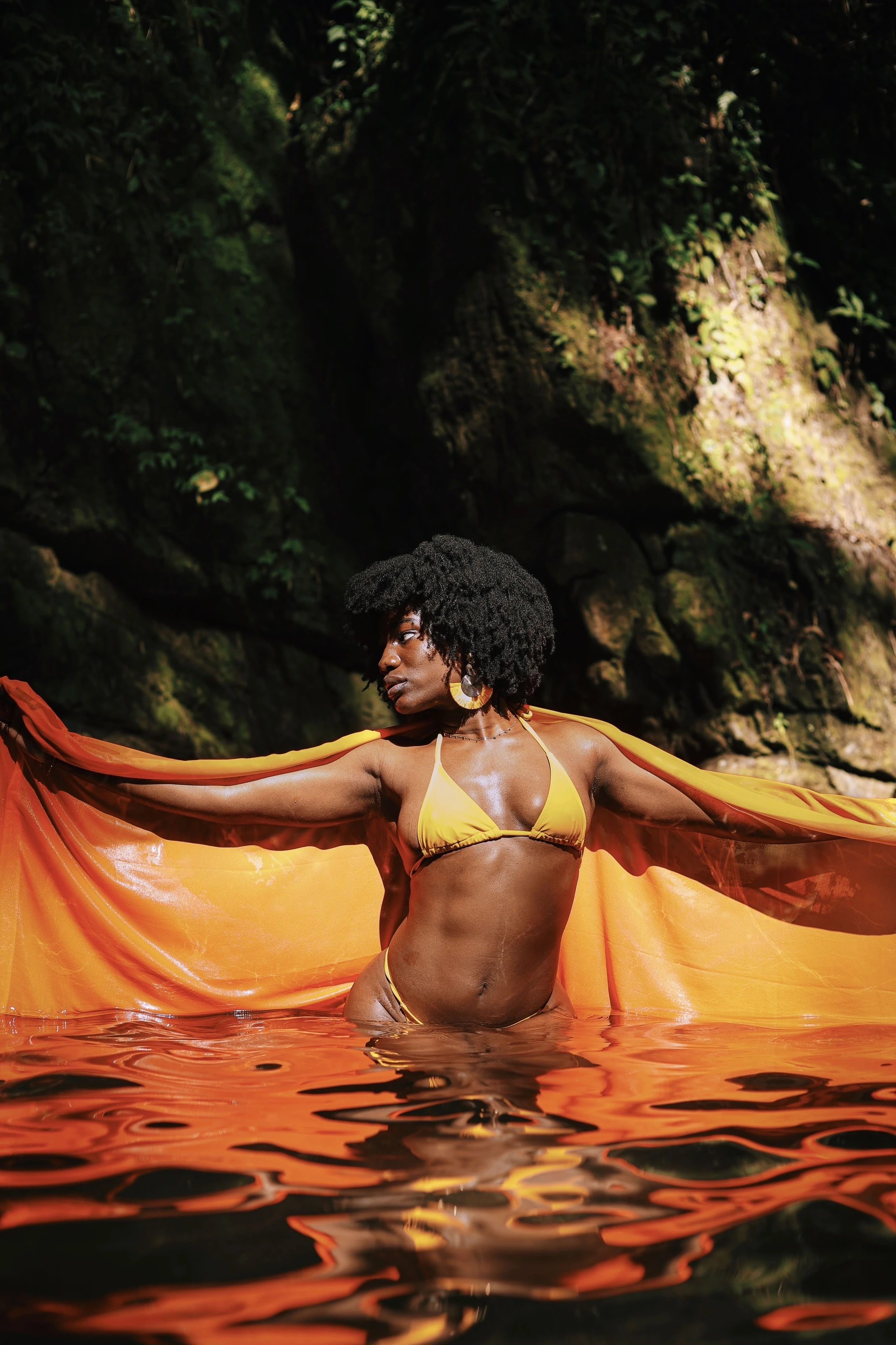 Portrait with flowing orange fabric beside the river