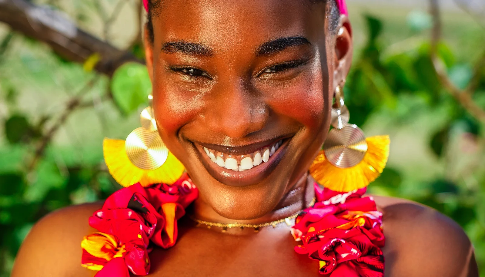 Smiling woman wearing yellow earrings and a colorful outfit
