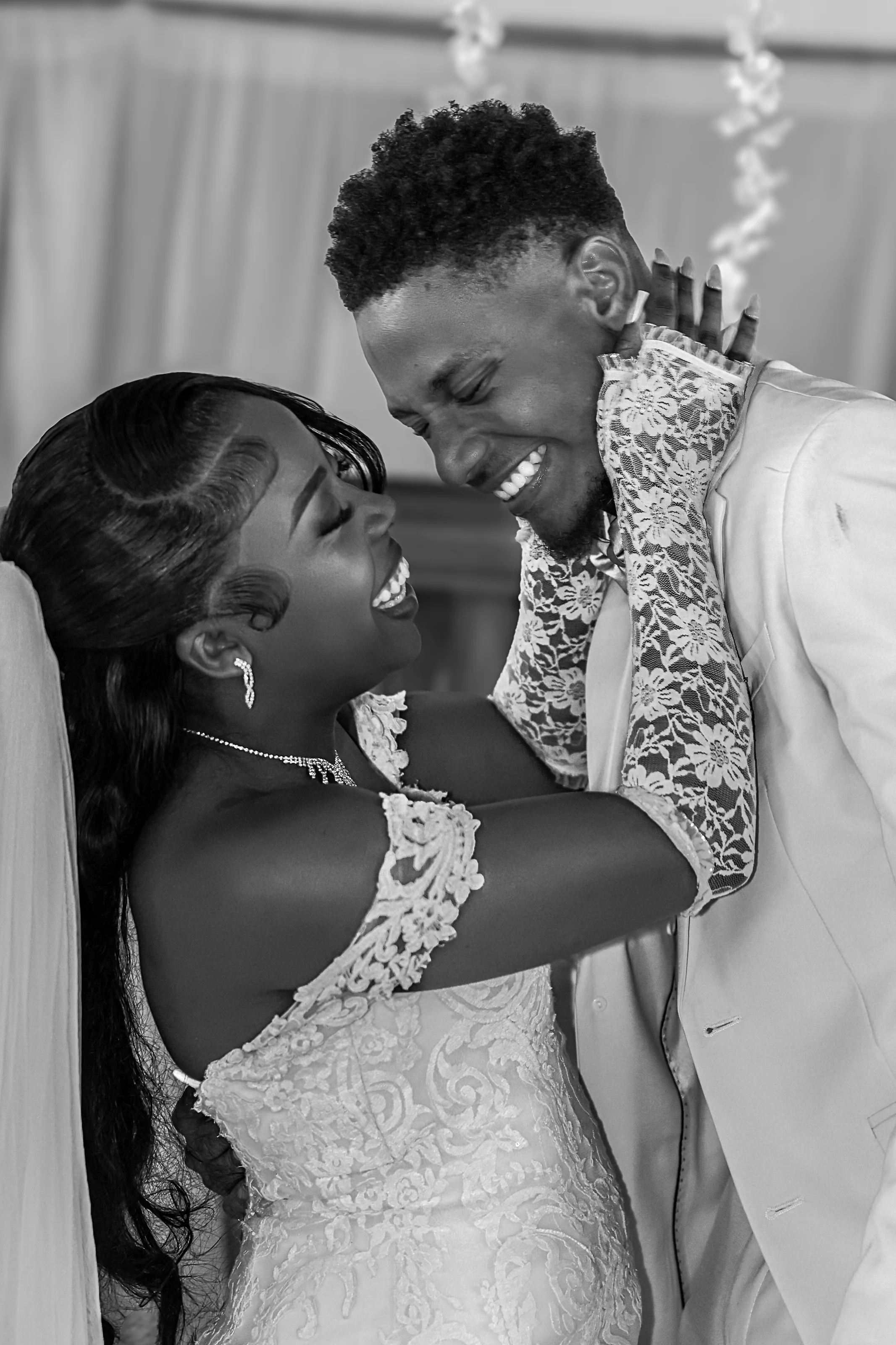 Black-and-white portrait of newlyweds smiling together
