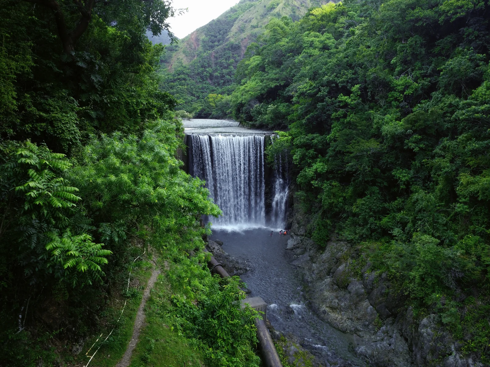 A waterfall surrounded by lush Jamaican hills